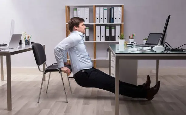 Professional demonstrating proper sitting posture at desk